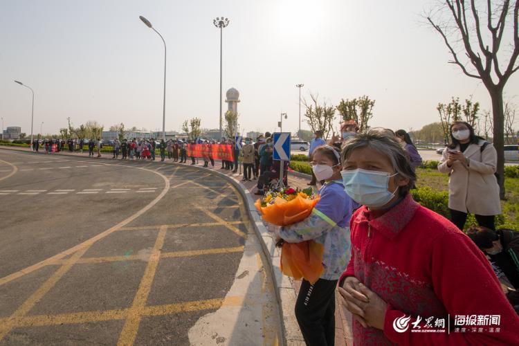 鲜花，祝福标语 民众自发机场欢迎英雄回家
