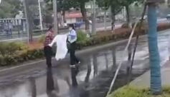 江苏一辅警小姐姐把雨衣让给双拐老人 网友：雨中天使小姐姐好美