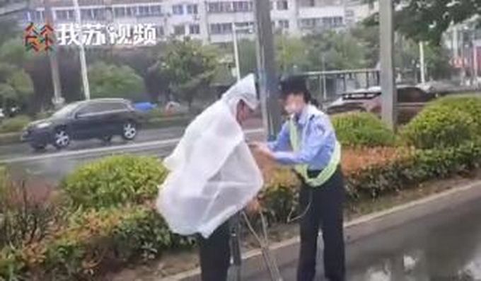江苏一辅警小姐姐把雨衣让给双拐老人 网友：雨中天使小姐姐好美