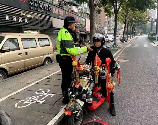 杭州小伙骑车闯红灯被拦下 一年不见，车上的东西又多了