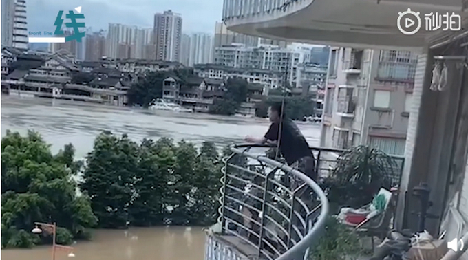 洪水淹到小腿肚!重庆大叔坐家门口沙发上看海 表情疲倦又无奈