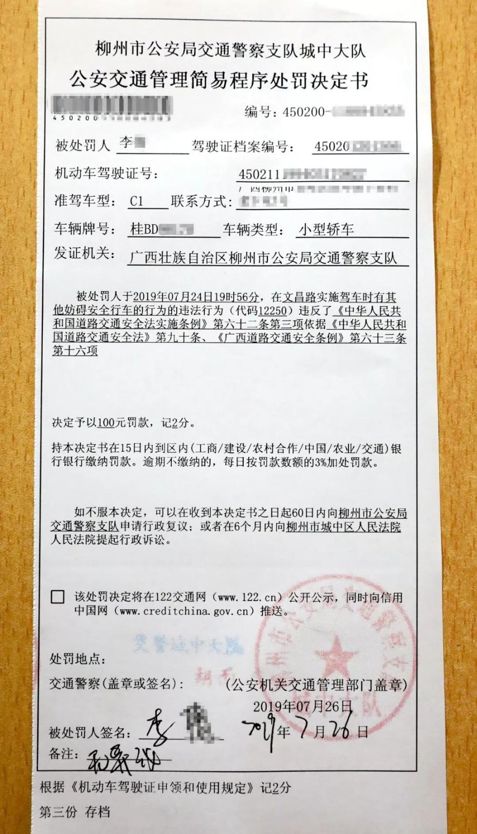 女司机驾车柳州马路中间龟速遛狗，交警罚款100元记2分