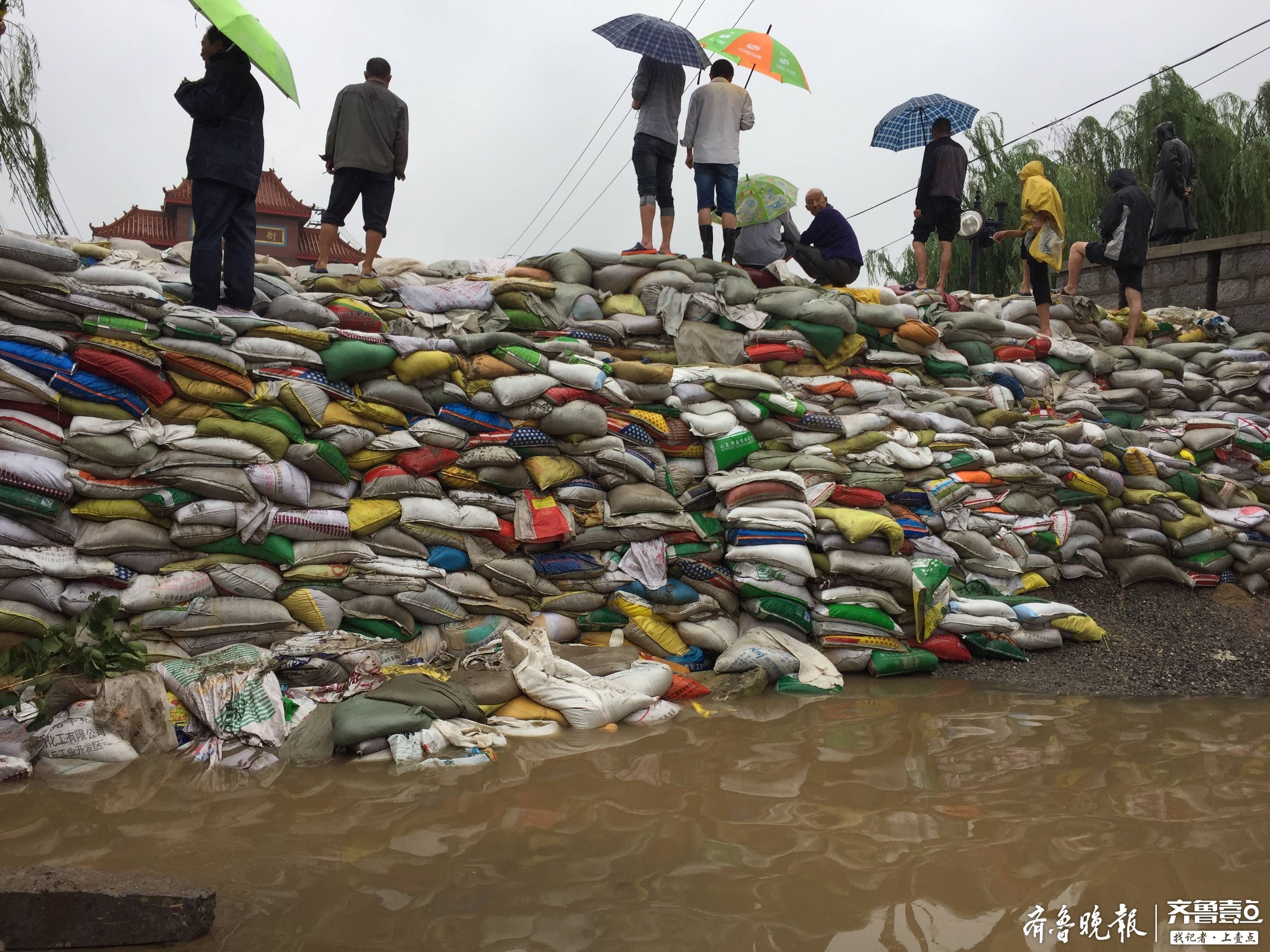章丘回村：400余吨沙子筑成防水墙，积水退去集市如约开放