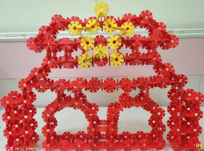 通过斜插,竖插再连接的方式将一个个红色的雪花片拼出圆形的国徽轮廓